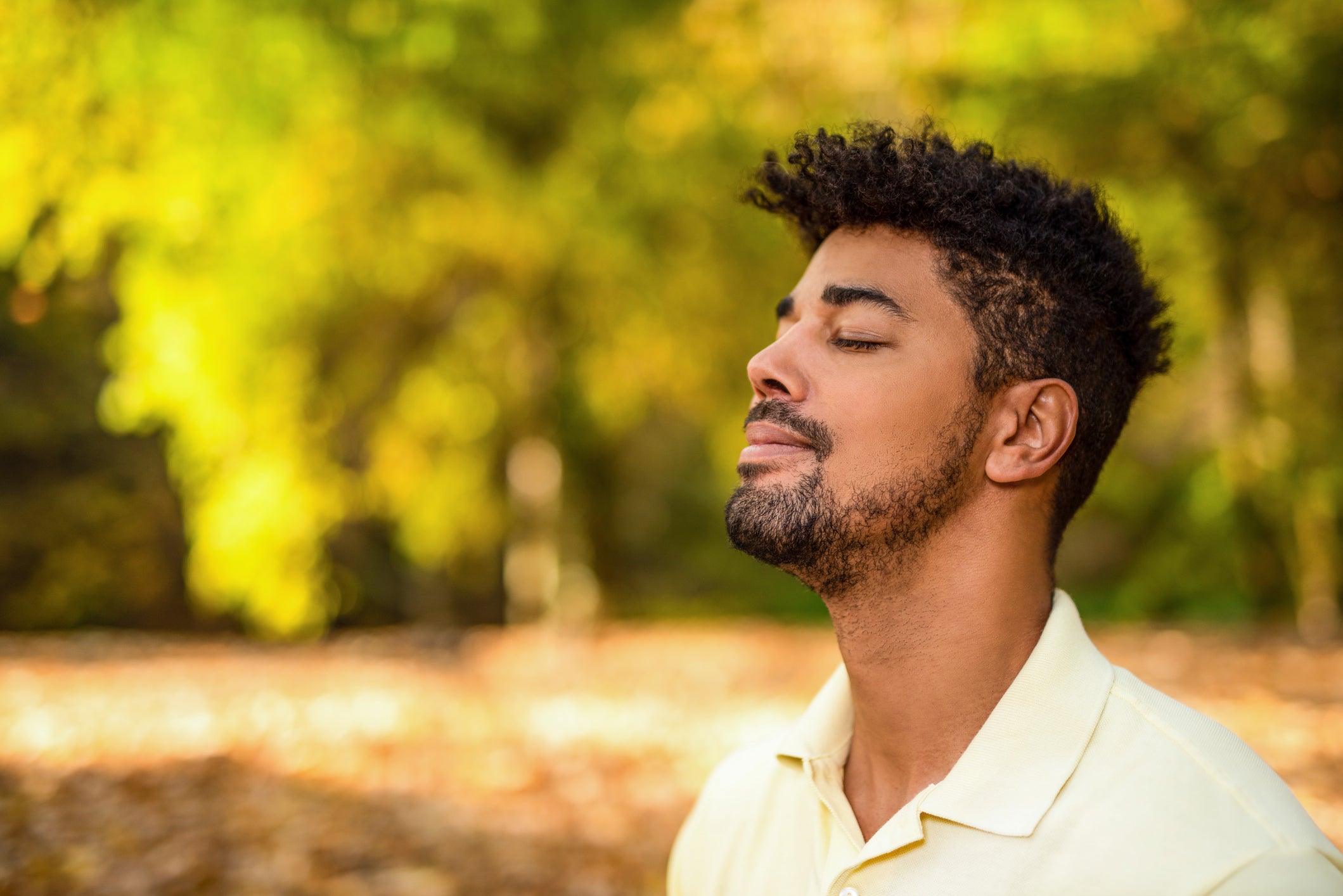 Young man meditating in nature on autumn day.