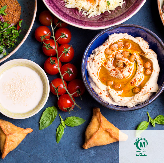 a spread of hummus, tomatoes, and spices