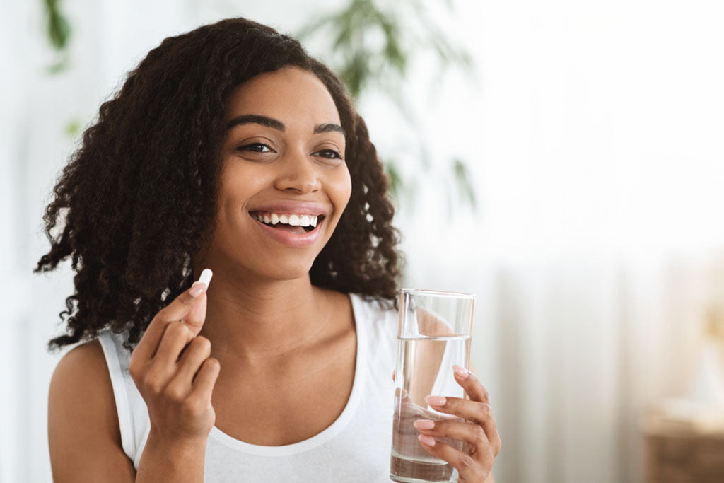 smiling woman takes supplement