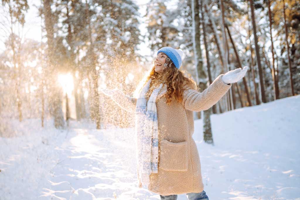 woman throwing snow in air portrait