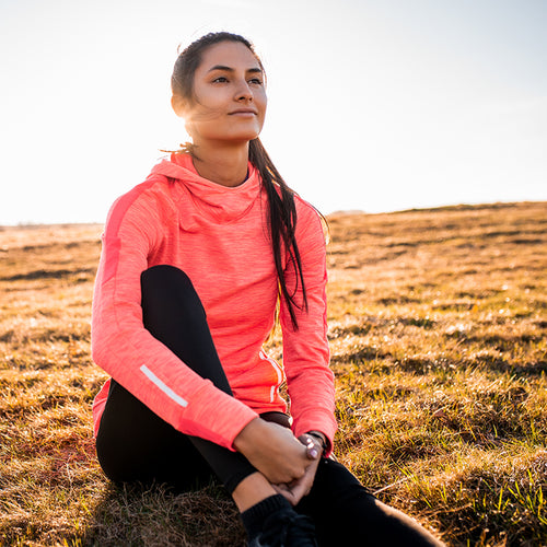 A healthful woman sits on a hill in reflection